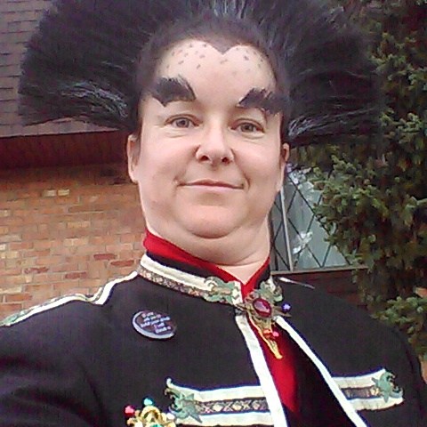 Cosplayer in fancy coat and feathery hair