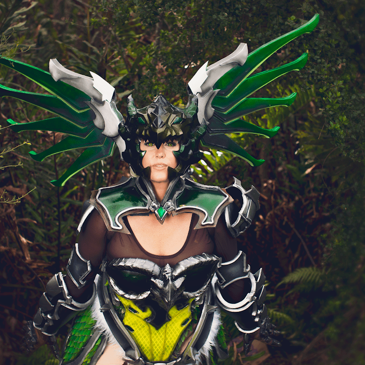 Woman in green scay armor and gold staff