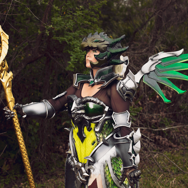 Woman in green scay armor and gold staff