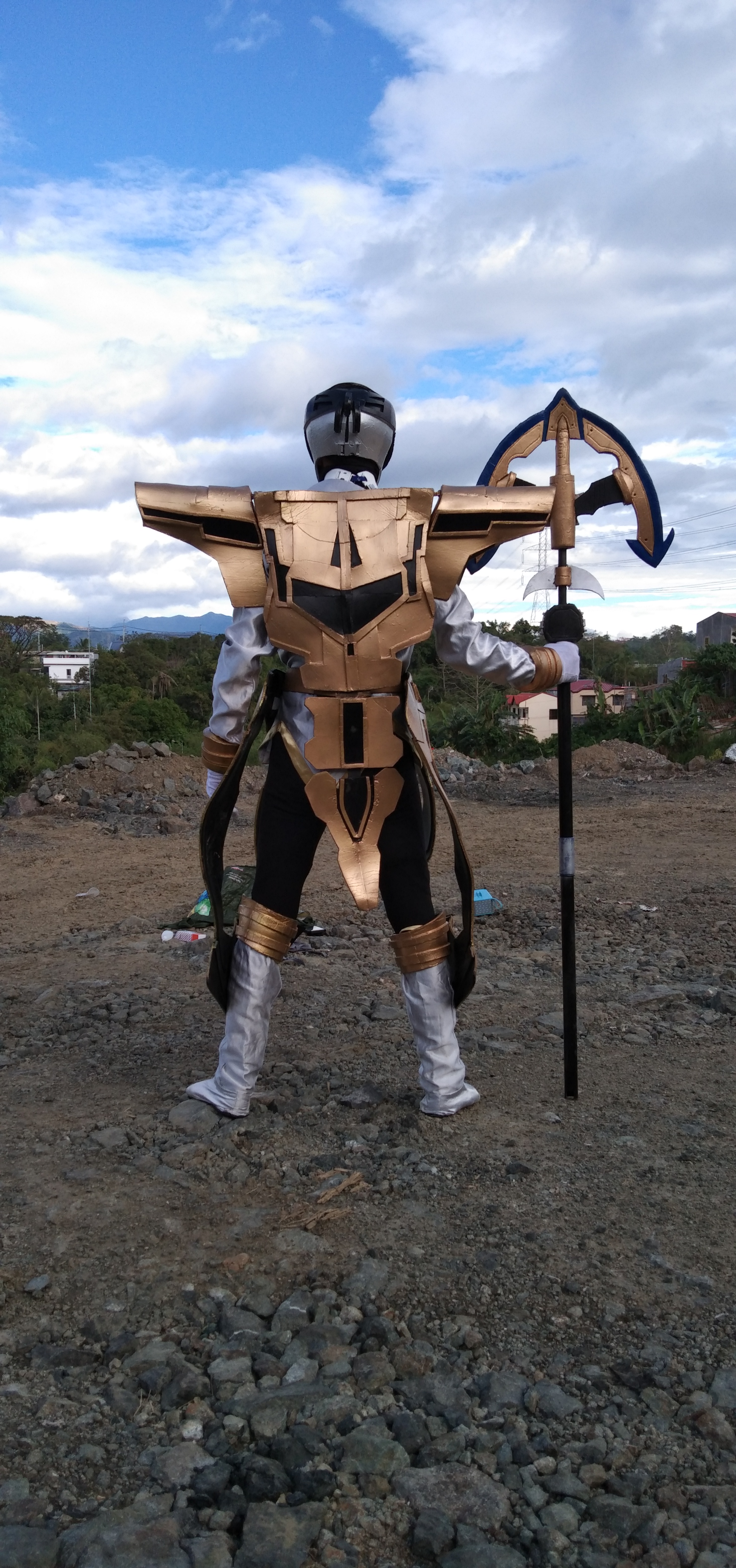 Cosplayer in white and gold, with staff