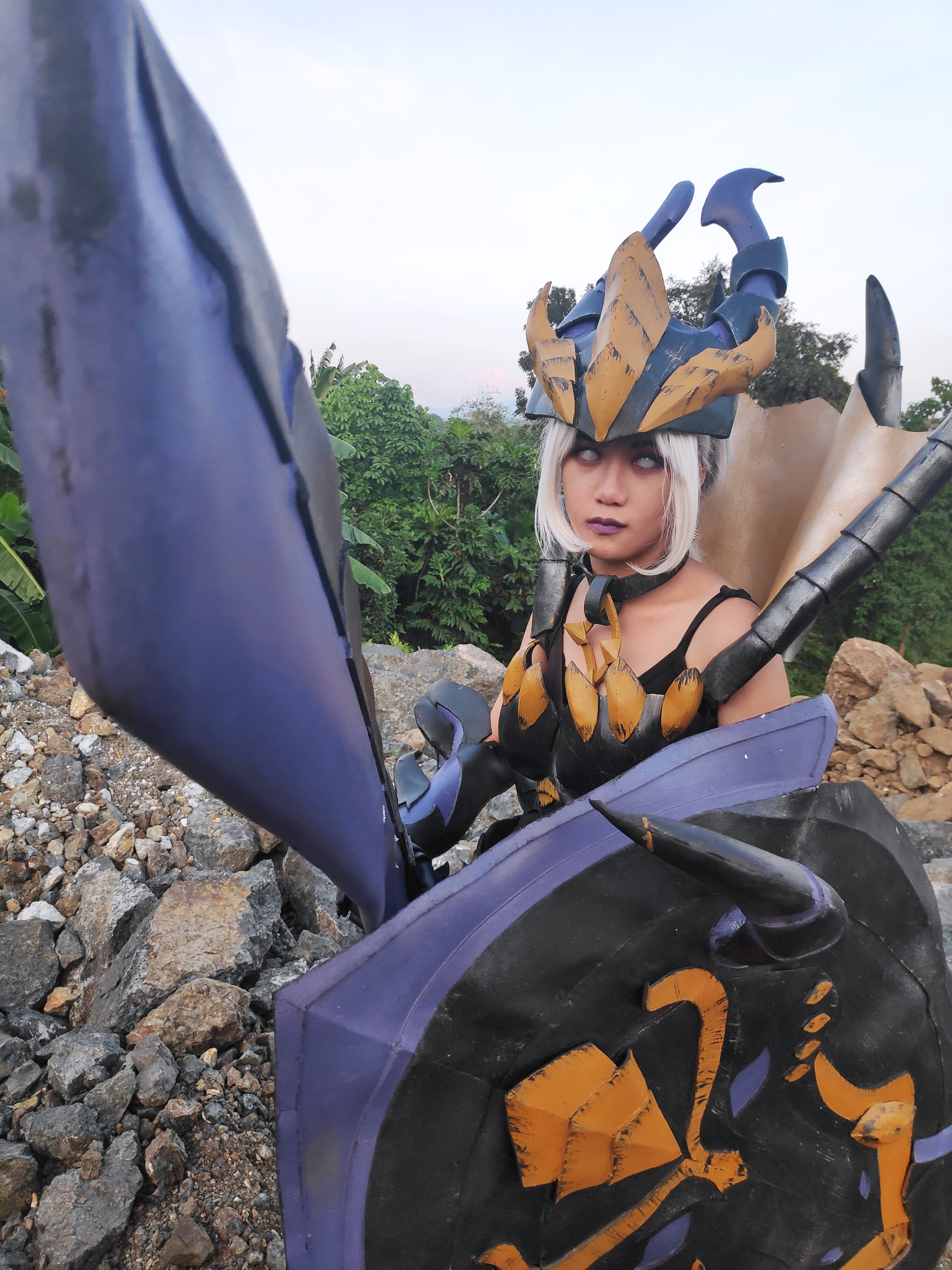 Armored woman pointing sword at camera