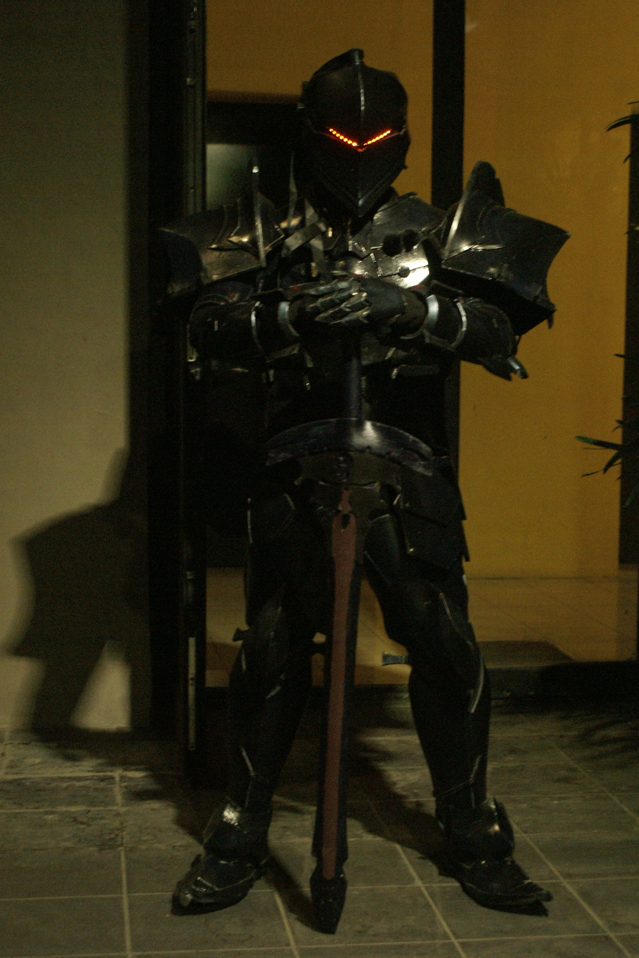 A dark, sharp-edged suit of armor with a sword and red lights for eyes.