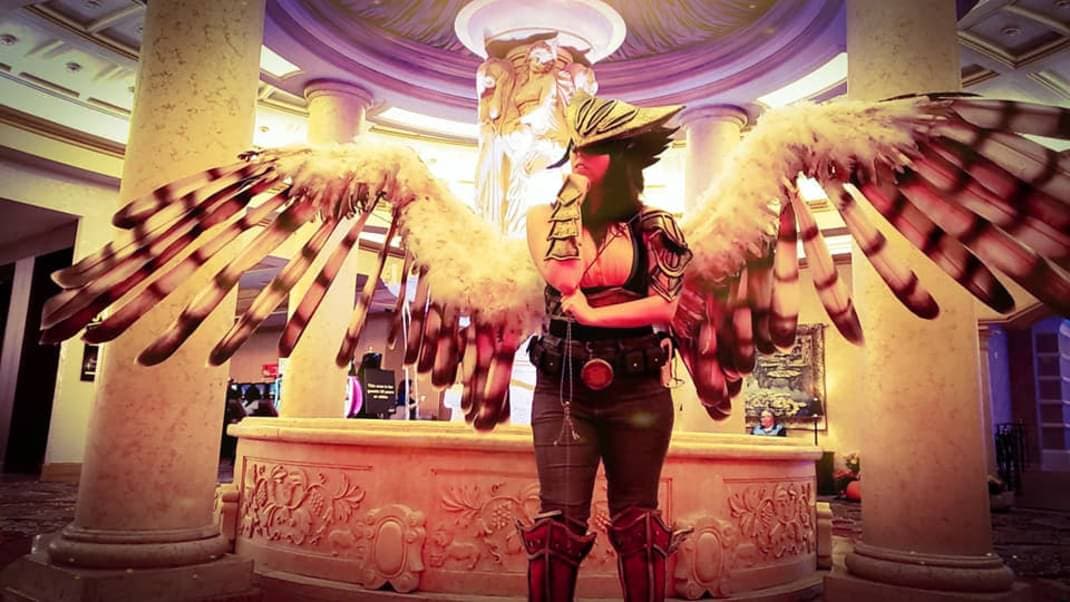 Armored version of hawkgirl. Gold and black hawk mask with a metallic finish, green leggings, red boots, big hawk wings that open and close, a mace, yellow top with arm bracers.