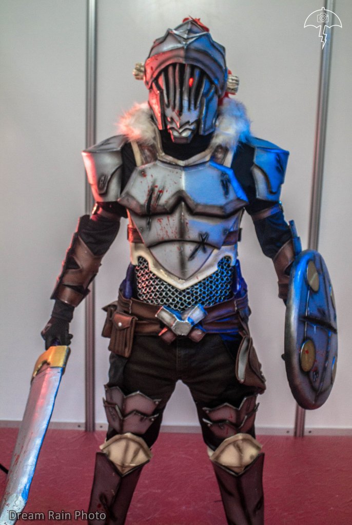 The main character of the series, a 20-year-old and experienced silver-rank adventurer who is only interested in hunting goblins, of which he possesses encyclopedic knowledge bordering on obsession. The jobs he does involve only goblins and he does not accept assignments of any other kind, though he often gets caught up in gruesome quests for reasons beyond his control. He has iron armor, with chain mail, horn and always carries a sword and shield. My cosplay is worked in eva rubber of different thicknesses, it has a chain mail on the abdomen that was made with thin wire one by one, the sword is lined in worbla and the shield with eva foam. I integrated a circuit of leds in the eye, to be able to simulate the bloodlust glow that it has in the anime. Some pieces are made of leather, such as the pants, belts and bags. My favorite details are the torn cuts that were made with dremel and iron and the splash of blood that was made with red paint. The cosplay is painted with aerosol sprays and detailed with an airbrush.