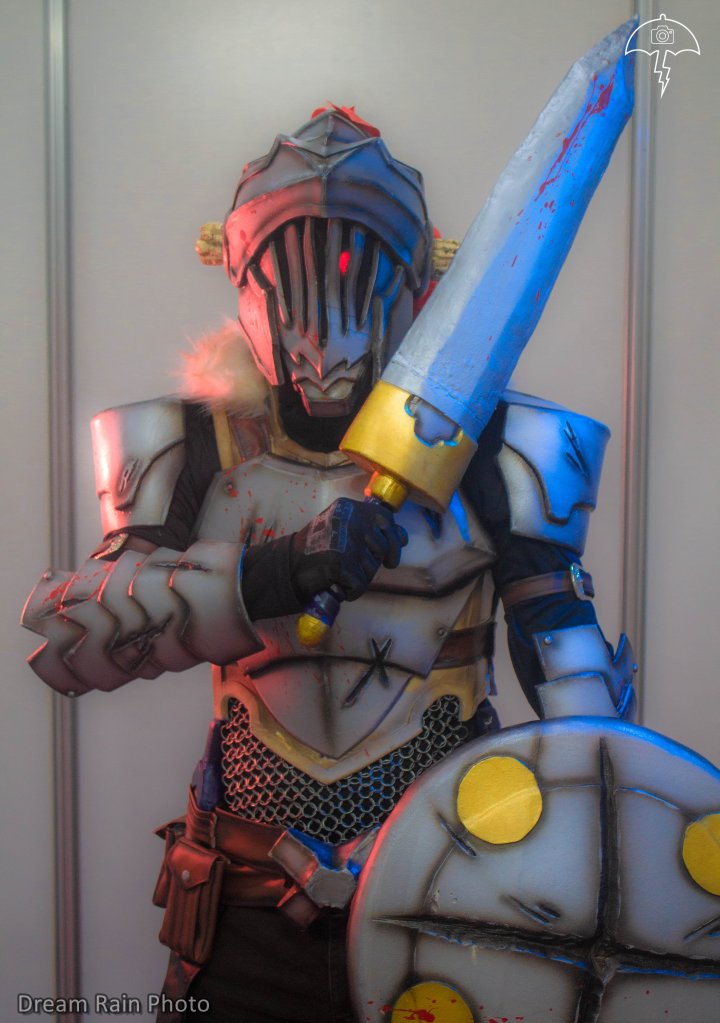 The main character of the series, a 20-year-old and experienced silver-rank adventurer who is only interested in hunting goblins, of which he possesses encyclopedic knowledge bordering on obsession. The jobs he does involve only goblins and he does not accept assignments of any other kind, though he often gets caught up in gruesome quests for reasons beyond his control. He has iron armor, with chain mail, horn and always carries a sword and shield. My cosplay is worked in eva rubber of different thicknesses, it has a chain mail on the abdomen that was made with thin wire one by one, the sword is lined in worbla and the shield with eva foam. I integrated a circuit of leds in the eye, to be able to simulate the bloodlust glow that it has in the anime. Some pieces are made of leather, such as the pants, belts and bags. My favorite details are the torn cuts that were made with dremel and iron and the splash of blood that was made with red paint. The cosplay is painted with aerosol sprays and detailed with an airbrush.