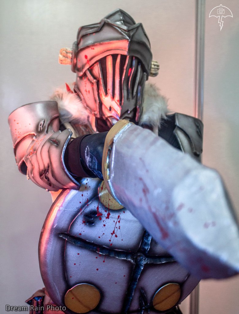 The main character of the series, a 20-year-old and experienced silver-rank adventurer who is only interested in hunting goblins, of which he possesses encyclopedic knowledge bordering on obsession. The jobs he does involve only goblins and he does not accept assignments of any other kind, though he often gets caught up in gruesome quests for reasons beyond his control. He has iron armor, with chain mail, horn and always carries a sword and shield. My cosplay is worked in eva rubber of different thicknesses, it has a chain mail on the abdomen that was made with thin wire one by one, the sword is lined in worbla and the shield with eva foam. I integrated a circuit of leds in the eye, to be able to simulate the bloodlust glow that it has in the anime. Some pieces are made of leather, such as the pants, belts and bags. My favorite details are the torn cuts that were made with dremel and iron and the splash of blood that was made with red paint. The cosplay is painted with aerosol sprays and detailed with an airbrush.